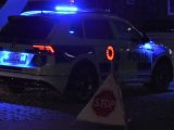 Bild på polisbil på kvällen med blåljus och stopptriangel