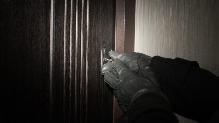 Bild på händer med handskar som försöker öppna en dörr