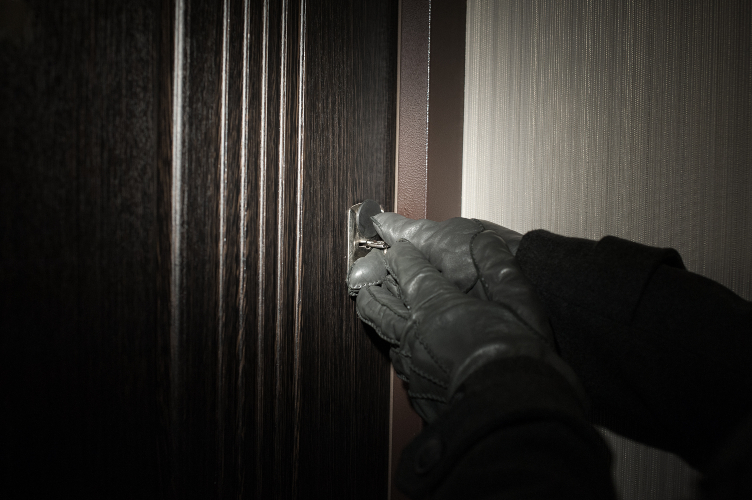 Bild på händer med handskar som försöker öppna en dörr