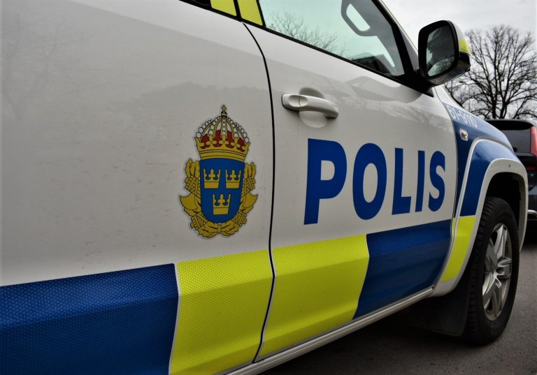 Sidan på en polisbil med text och emblem