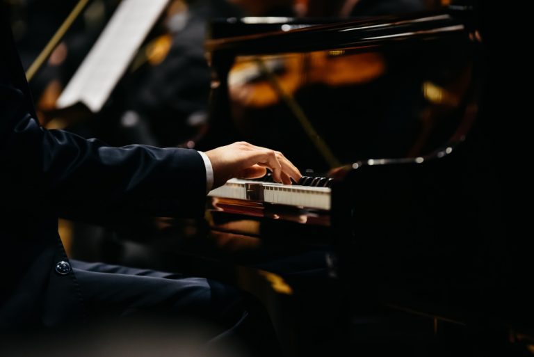 Pianist som spelar på ett piano sett från sidan