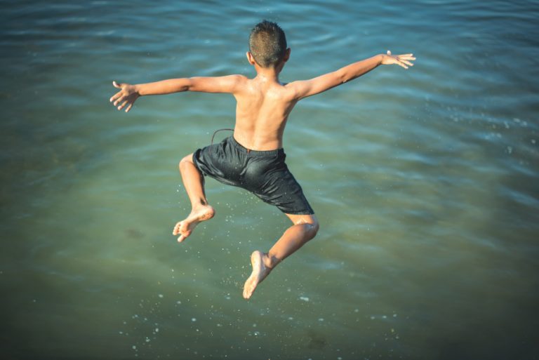 Pojke hoppar i vattnet