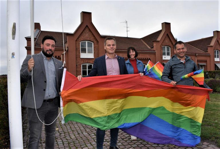 Representanter från Oskarshamns kommun hissar prideflaggan utanför stadshuset