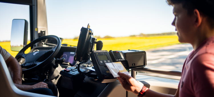 Resenär betalar avgift på bussen