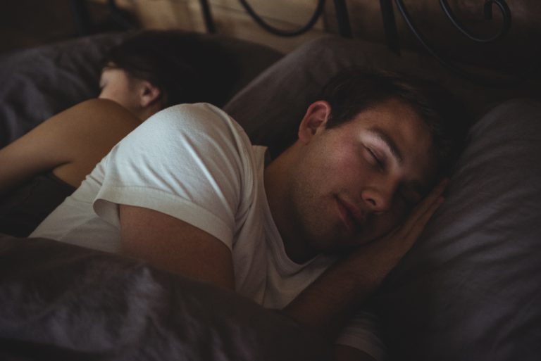 Ett par som ligger och sover i en säng