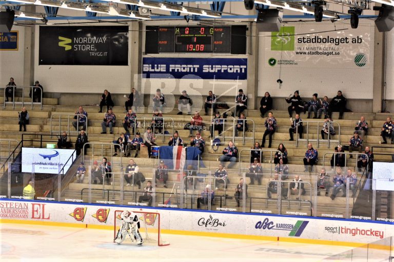 Publik på hockeymatch. Folk sitter med coronaavstånd på en ståplatsläktare i Oskarshamn.