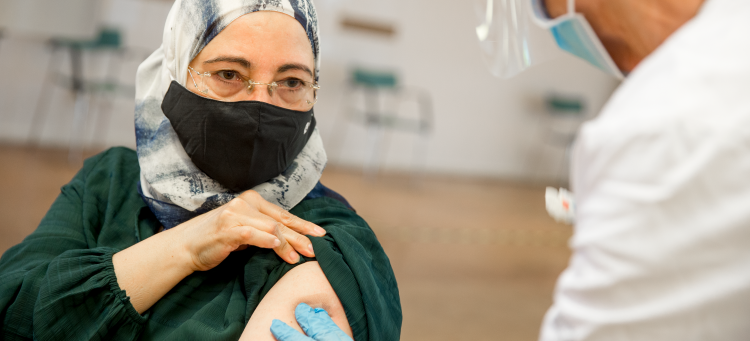 covid-19-vaccin, en person får en spruta på en hälsocentral