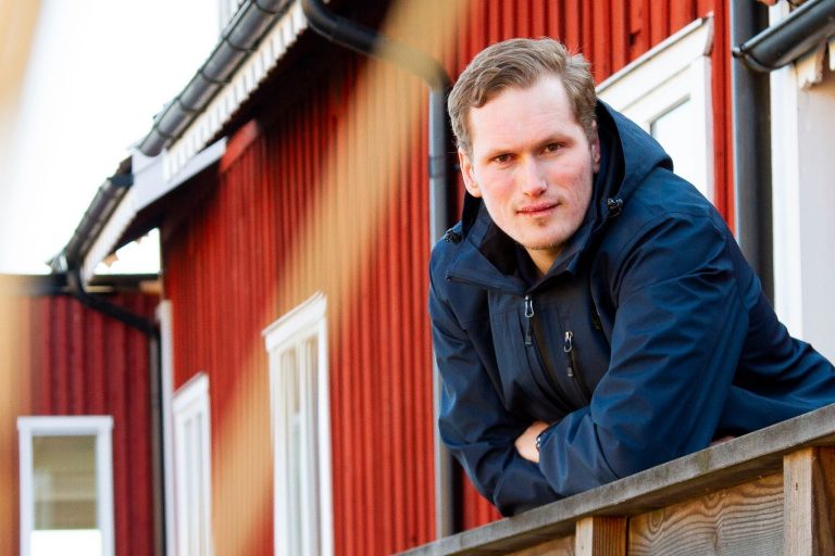 Albin Borg med rött hus i bakgrunden