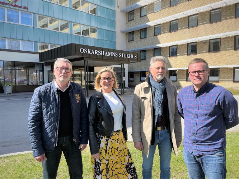 Fyra politiker står vid Oskarshamns sjukhus