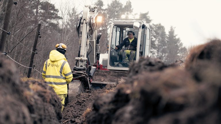 Grävmaskin som gräver ner fiber