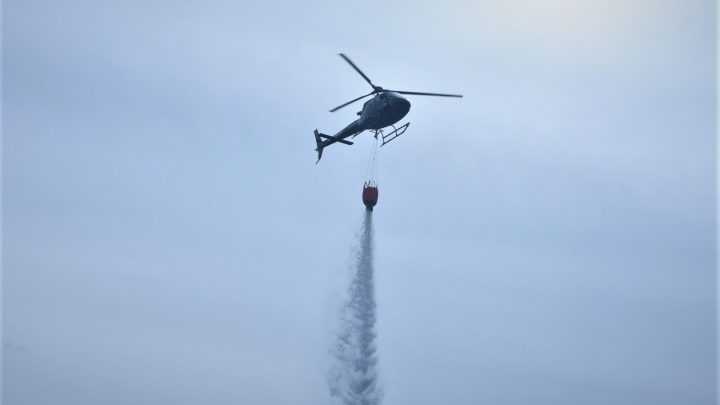 Helikopter vattenbombar en skogsbrand utanför Fliseryd