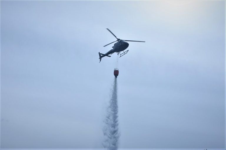 Helikopter vattenbombar en skogsbrand utanför Fliseryd