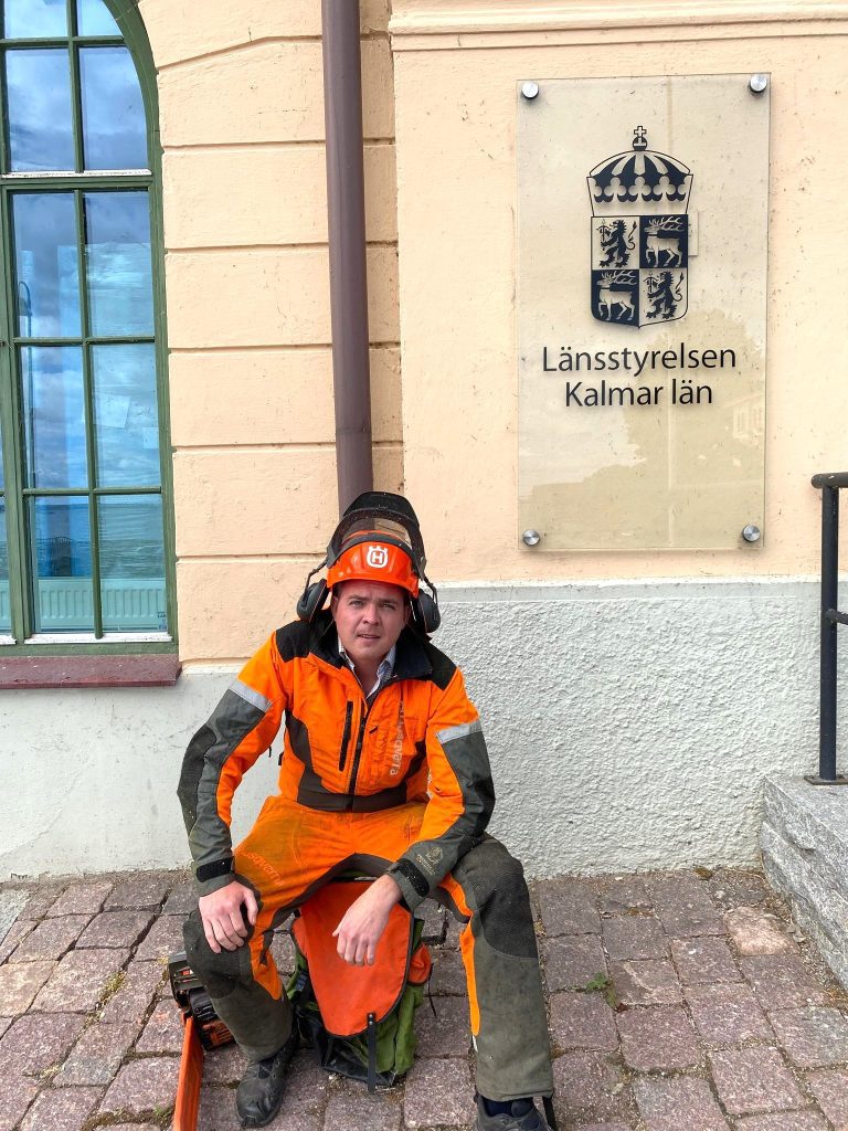 Carl-Wiktor Svensson (KD) i skogshuggarkläder vid länsstyrelsens entré i Kalmar