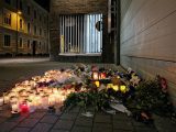 Blommor och tända ljus på mordplatsen på Slottsgatan