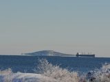 Blå Jungfrun och ett lastfartyg en solig vinterdag