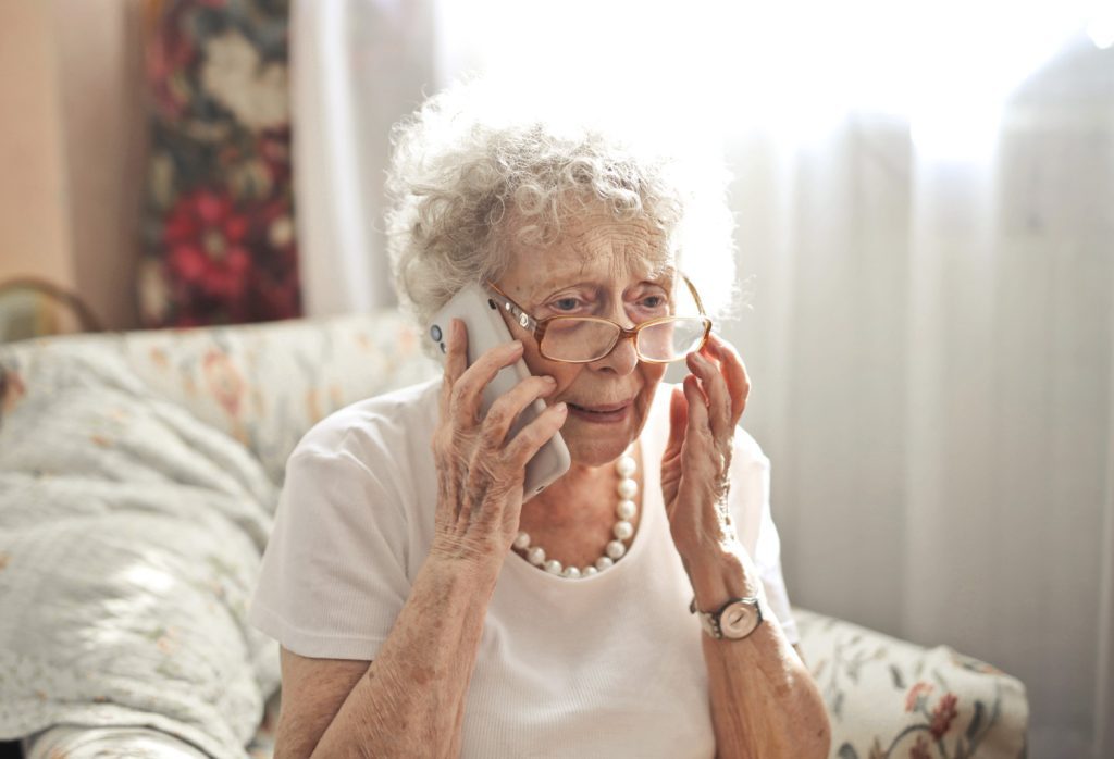 Äldre kvinna som pratar i mobilen