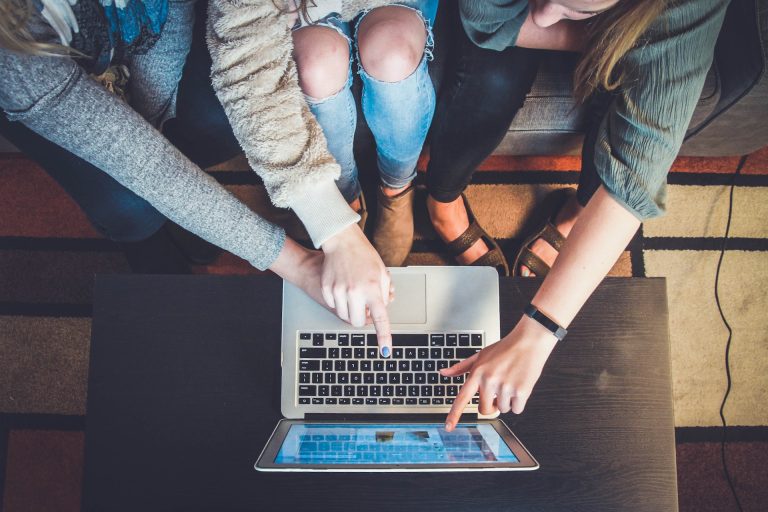 Personer som pekar på en laptop