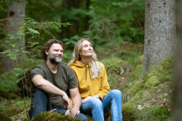 Man och kvinna som sitter i skogen