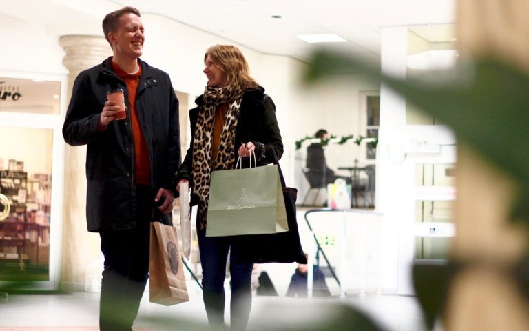 Man och kvinna skrattar när de shoppar