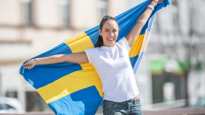 Kvinna håller svenska flaggan