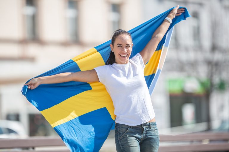 Kvinna håller svenska flaggan