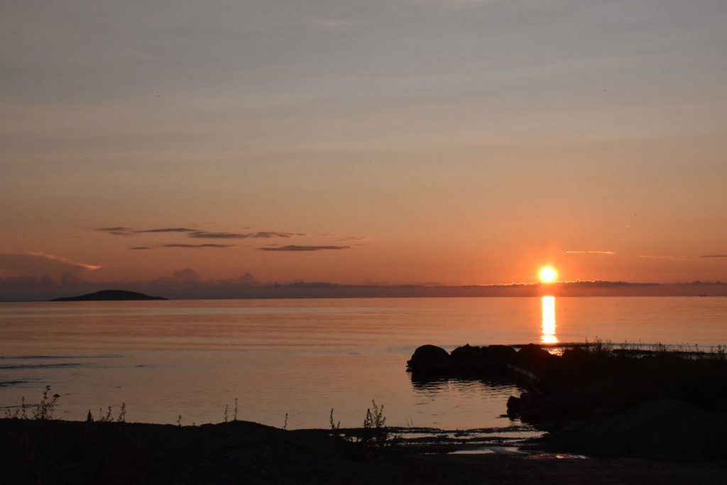 Solnedgång vid Byrums raukar med utsikt mot Blå Jungfrun