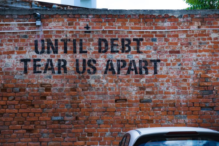 Vägg med texten Until debt tear us apart