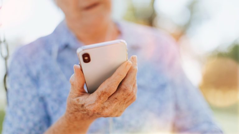 Äldre kvinna pratar i mobilen