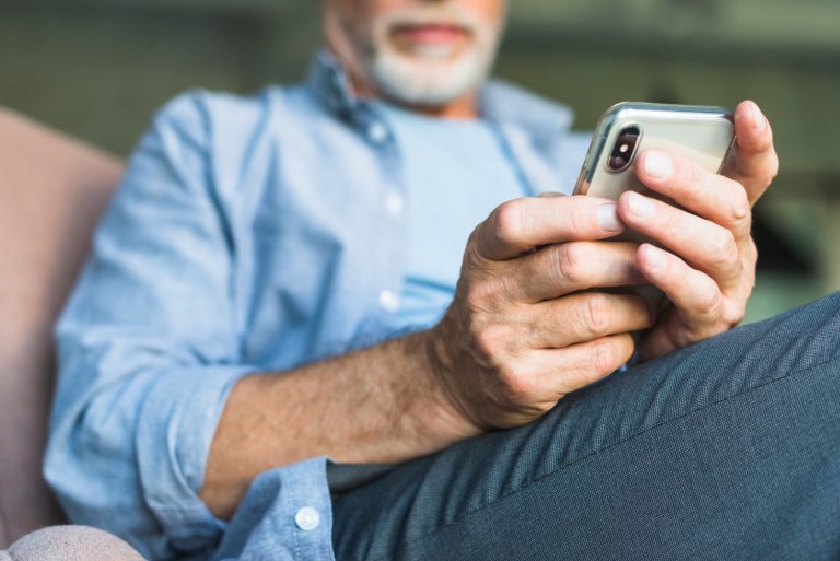 Äldre man som använder mobiltelefon