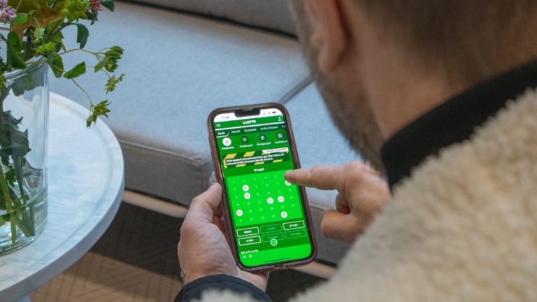 Man som tittar på mobilen med Lotto