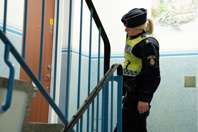 Kvinnlig polis utanför dörr i trapphus