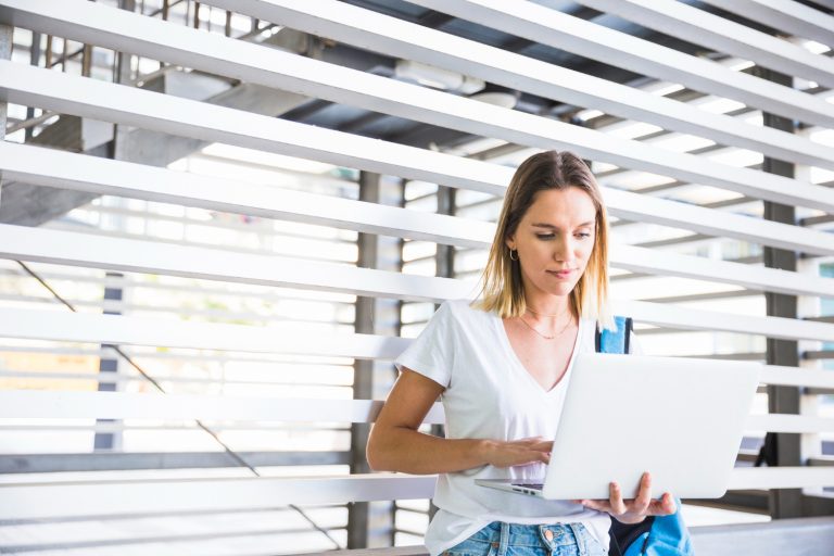 Ung kvinnlig student med laptop