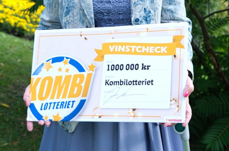 Kvinna med vinstcheck från Kombilotteriet