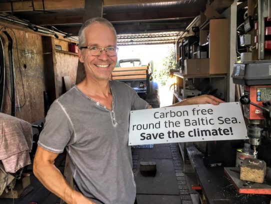 Sven mit Schild: „Carbon free round the Baltic Sea. Save the climate!“