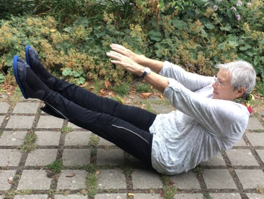 Frau macht Yoga-Übung auf dem Boden