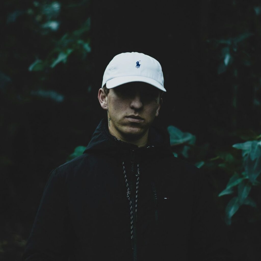 Ung man med Ralph Lauren keps och parfym som doftar sportigt och fräscht. Han går en skogspromenad som kvällsmotion