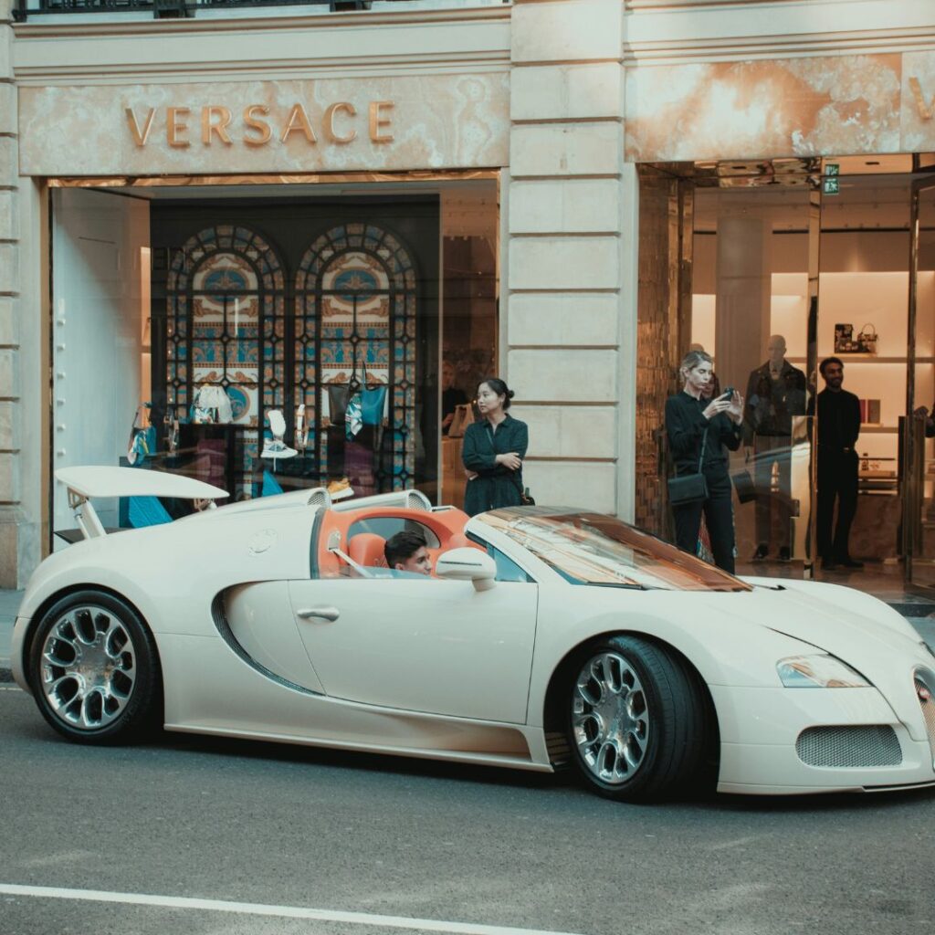 Versace butik i elegant byggnad med en lyxbil framför som symboliserar målgruppen för Versace parfym.