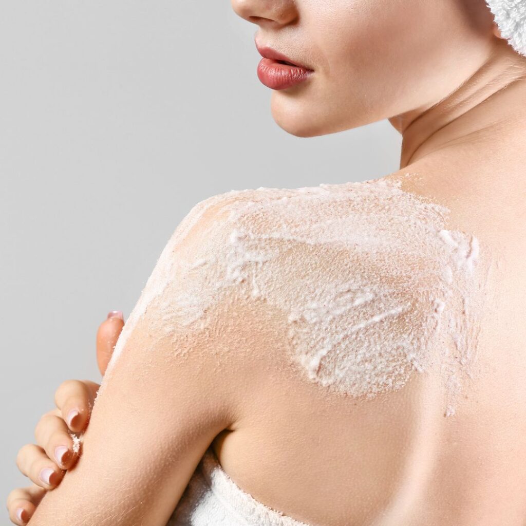 Body scrub från Rituals applicerad på kvinnas axel för att ta hand om kroppen och dess hud i doftande och kvalitativ body scrub.