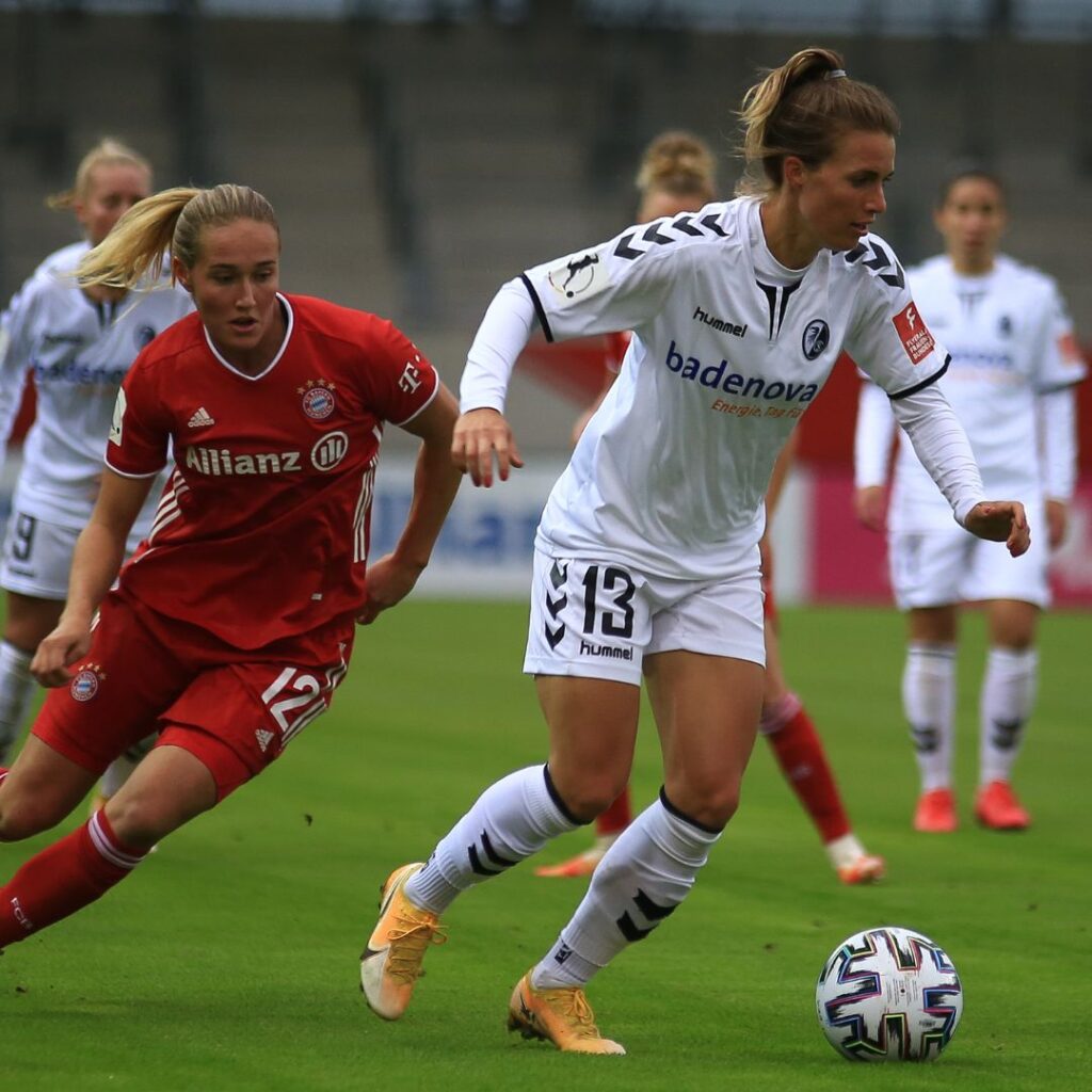 Damfotboll i en spännande match där de kämpar för att vinna. De doftar fotbollsparfym som utstrålar en feminin och djärv doft.