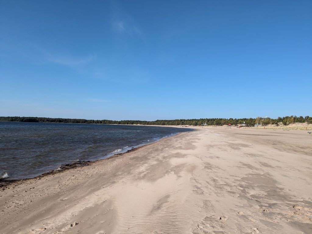 Yyterin hiekkarantaa. Kuvassa näkyy tummaa merta, kirkkaan sinistä taivasta ja reilun kilometrin kaistale hiekkarantaa.