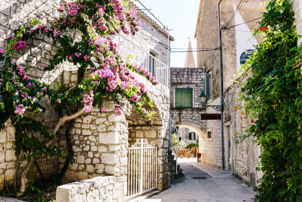 the lovely streets with flowers in Stari Grad, located on Hvar, one of the best islands to visit along the Dalmatian coast of Croatia