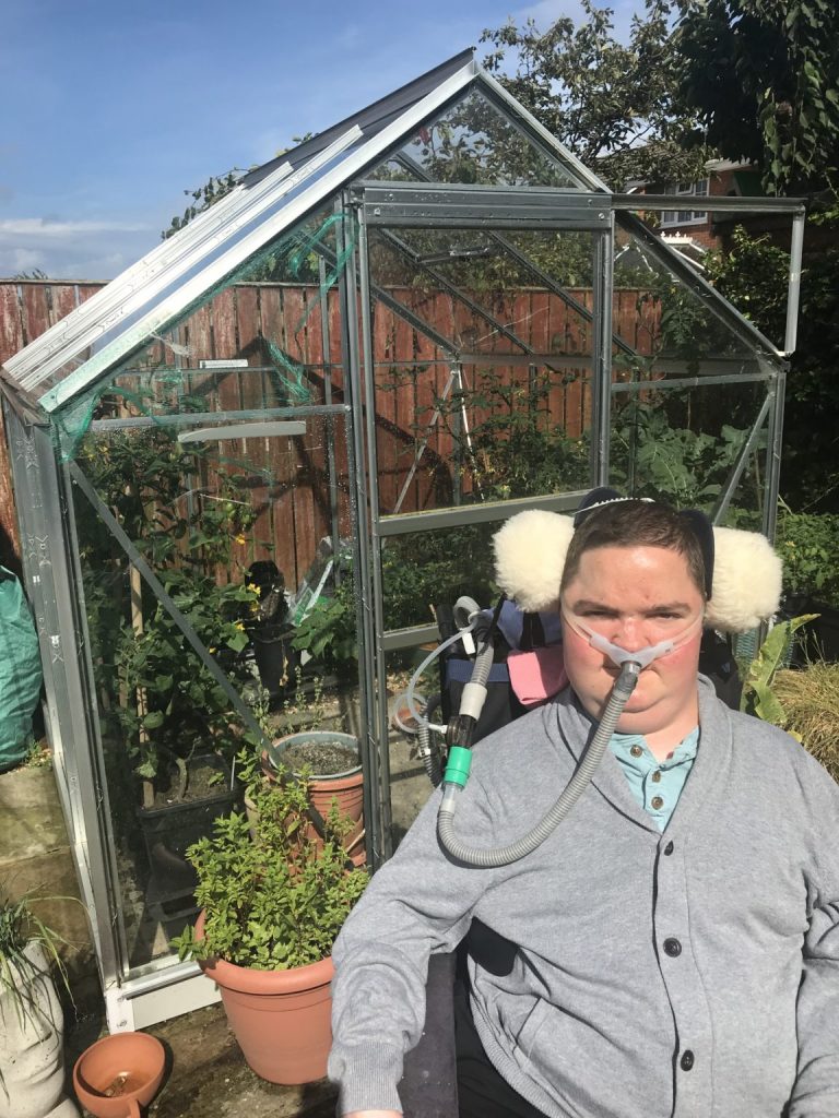 ROBERT SLEIGHT in front of his greenhouse