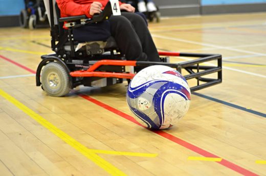 Image shows powerchair football in play. Photo credit to Inertia Creative