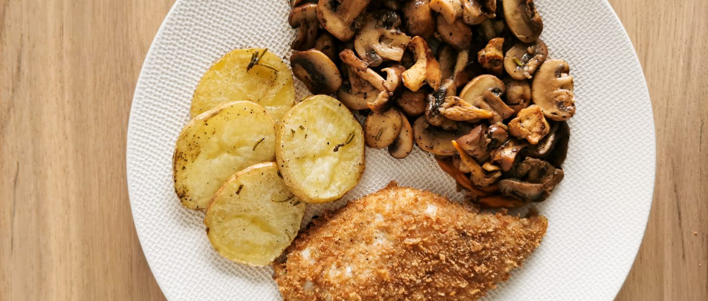 Foto van de kipfilet vergezeld van champignons en schijfjes aardappel