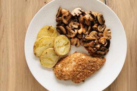 Foto van de kipfilet vergezeld van champignons en schijfjes aardappel