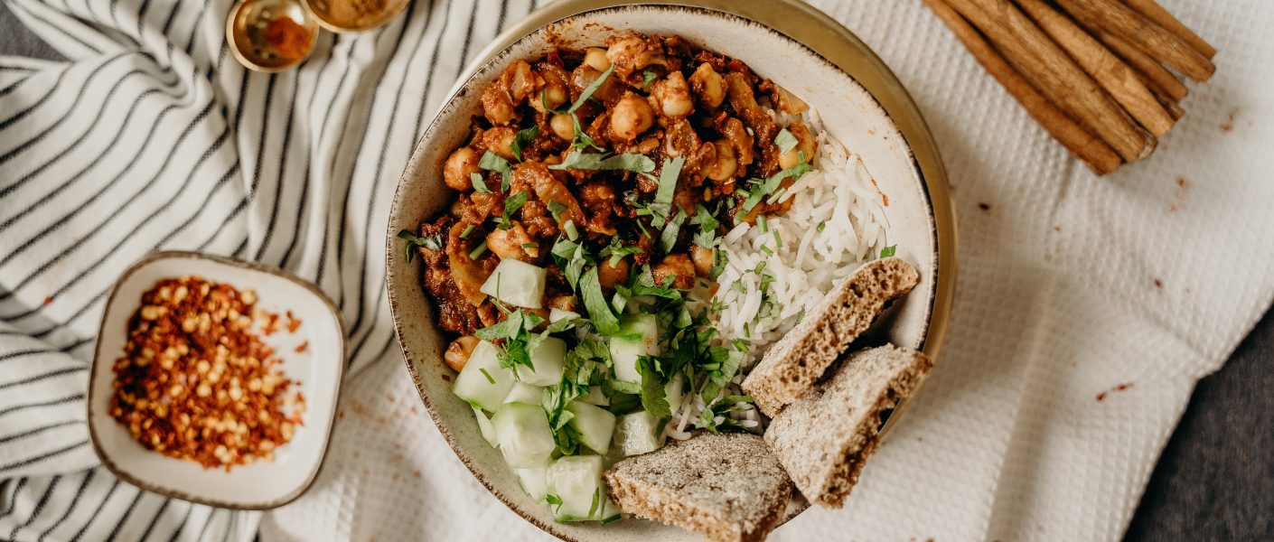 Foto van vegetarische curry met kruiden er rond.