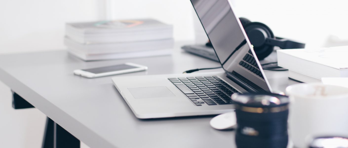 Foto van een home office met laptop en koffiemok.