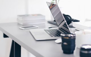 Foto van een home office met laptop en koffiemok.