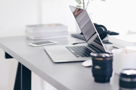 Foto van een home office met laptop en koffiemok.