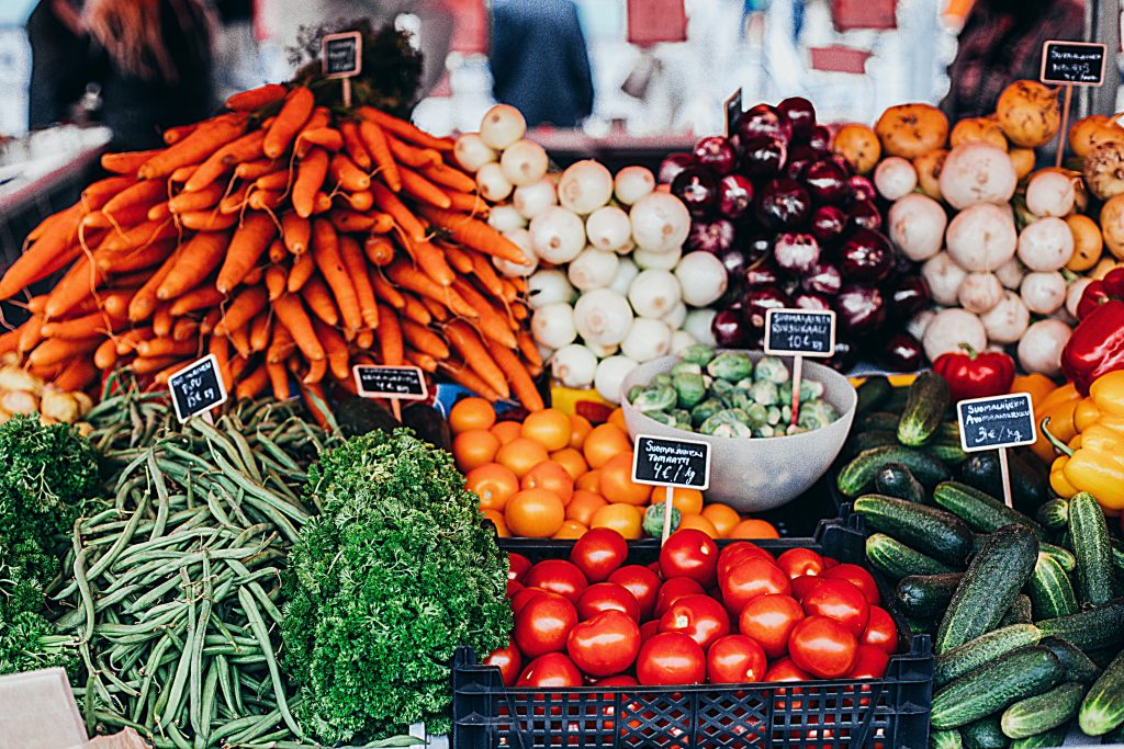 Foto van een marktkraampje met verschillende soorten groenten.